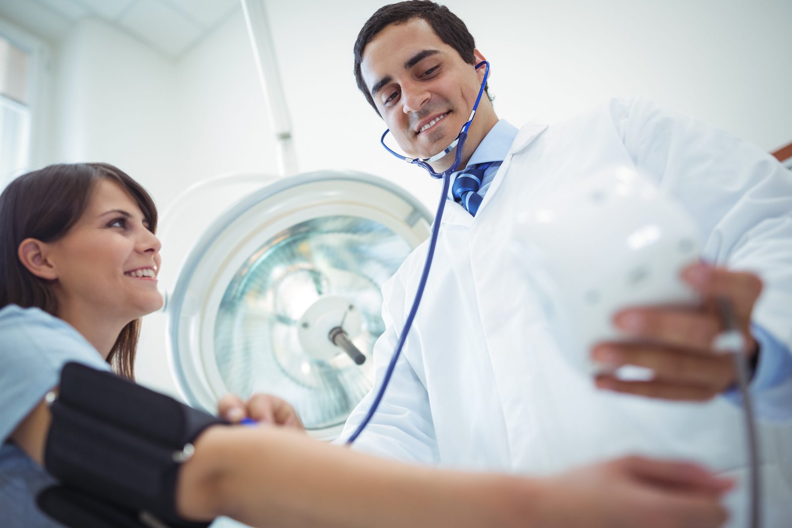 Doctor checking female patient blood pressure in the hospital